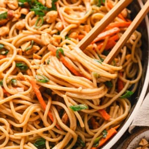Chopsticks in a bowl of peanut noodles