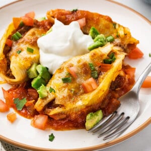 Taco stuffed shells on a plate with sour cream