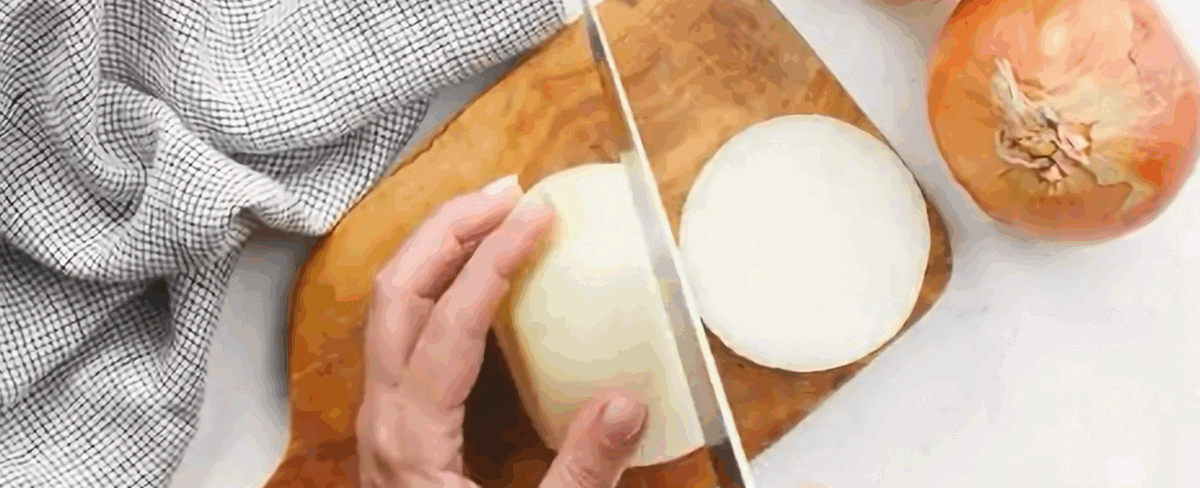 Slicing onions on a wooden cutting board.