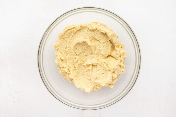 Butter cookie dough in a glass mixing bowl.