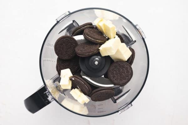 Oreos and cubed butter in a food processor.