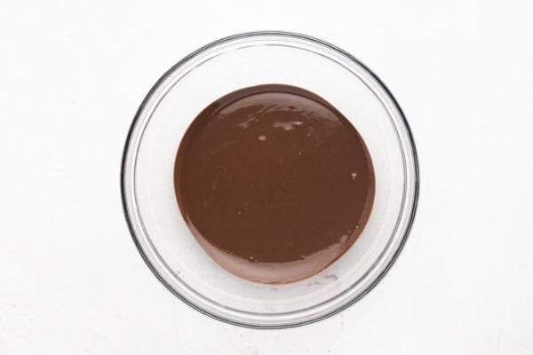 Melted chocolate in a glass mixing bowl.