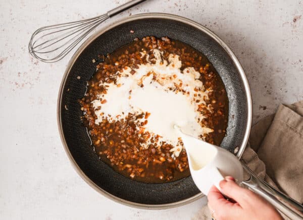 Adding heavy cream to a red wine sauce n a pan