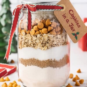 cookie mix layered in a glass jar with holiday tag and ribbon