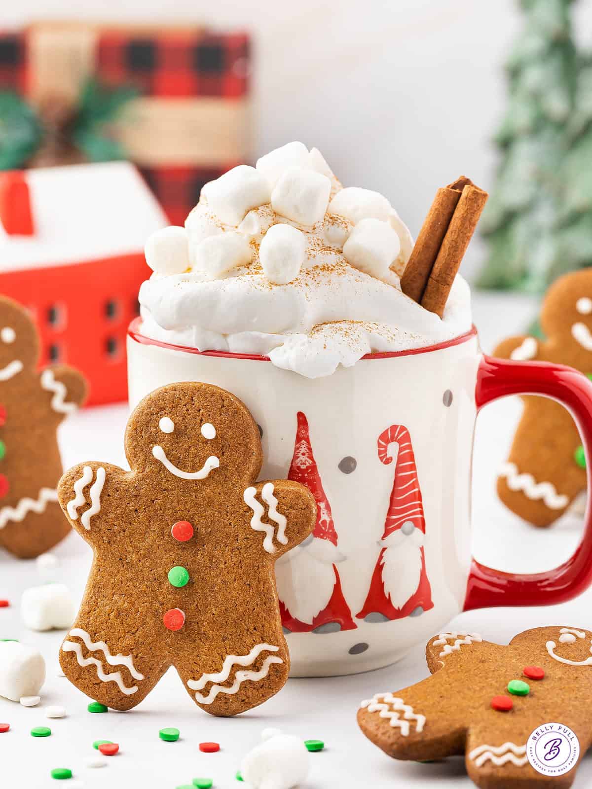 A gingerbread man cookie next to a mug of hot cocoa