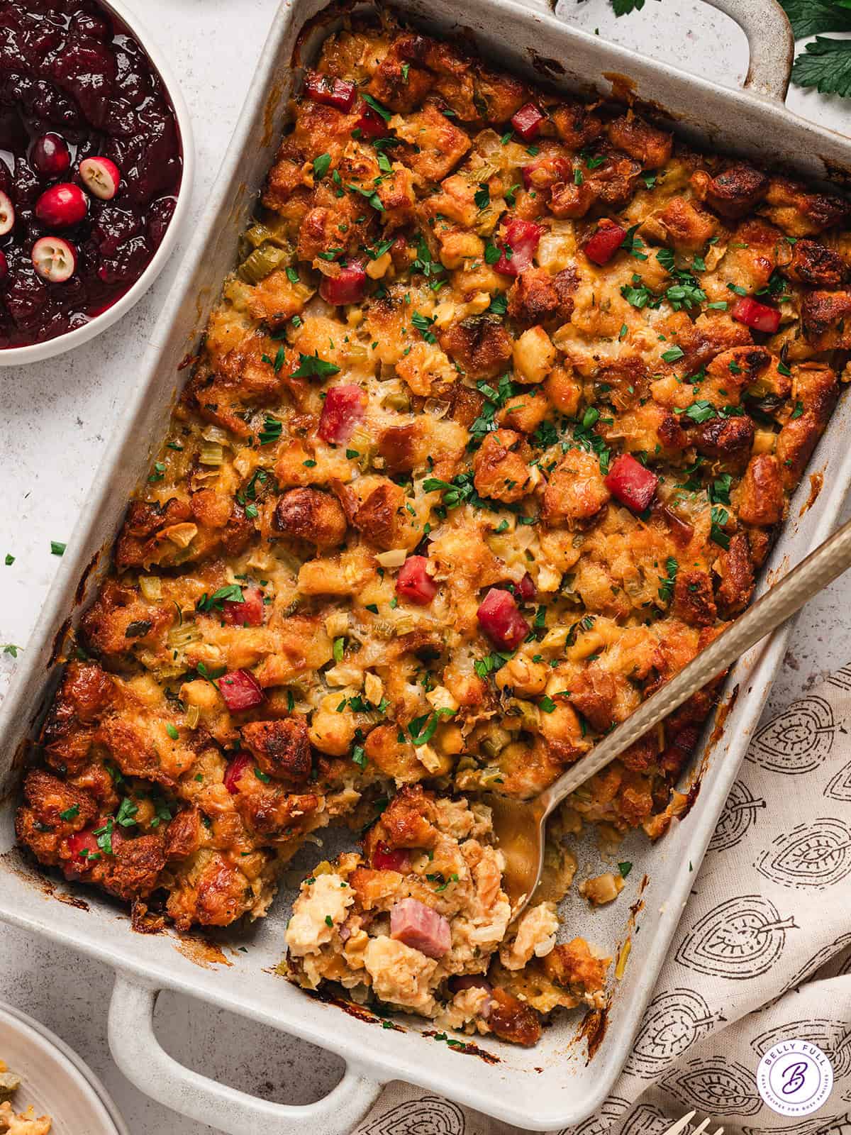 Potato bread stuffing in a baking dish with a spoon