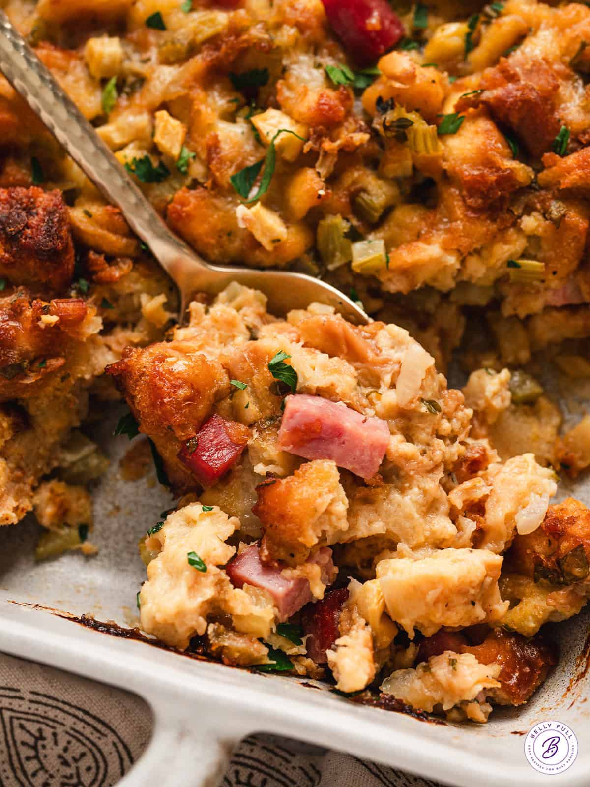 Close up of a spoon in a dish of potato bread stuffing