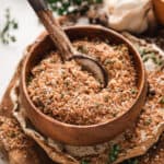 Side view of prime rib rub in a bowl with a spoon.