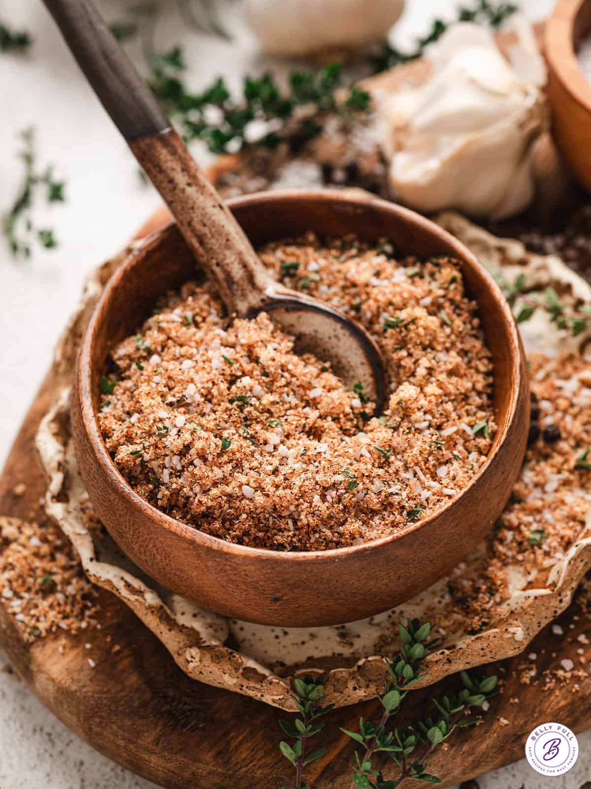 Side view of prime rib rub in a bowl with a spoon.