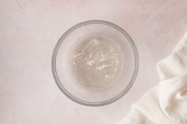 Unflavored gelatin in a bowl with ice whater