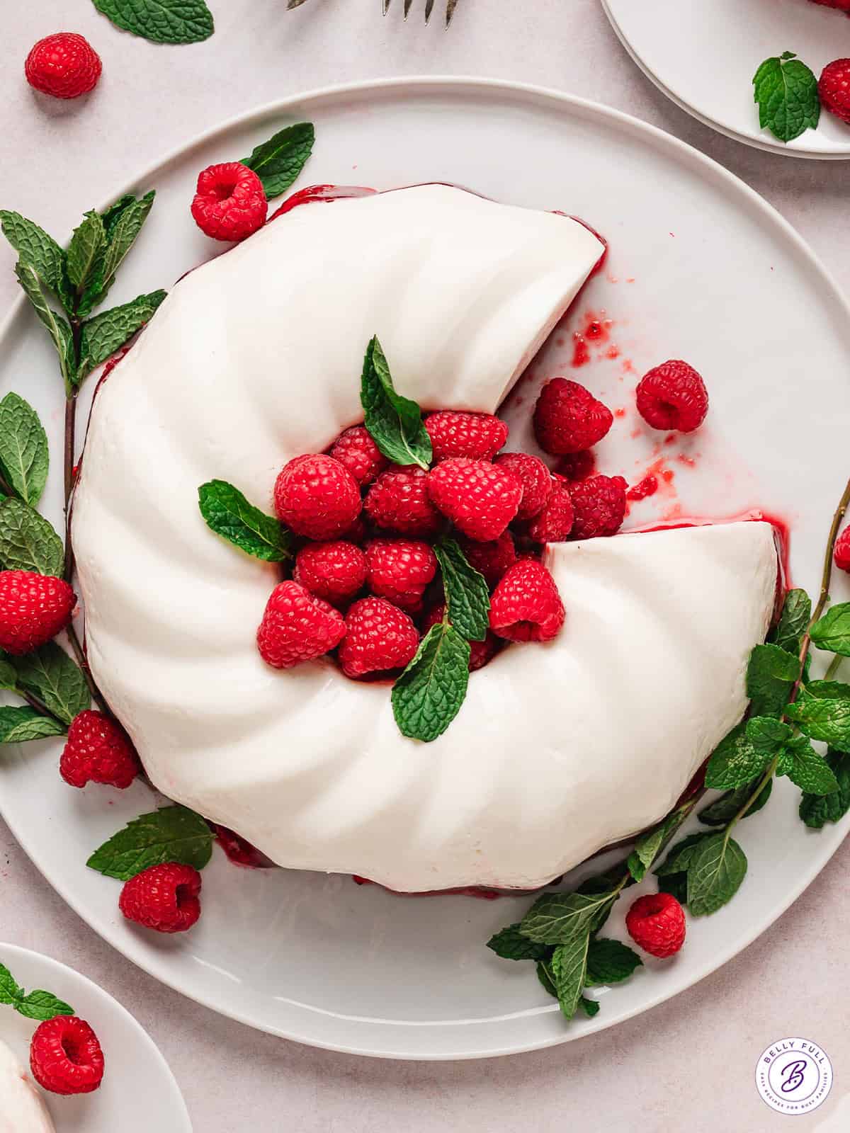 Overhead view of snowy raspberry jello mold with a slice missing