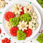 Overhead view of Christmas spritz cookies on a white plate.