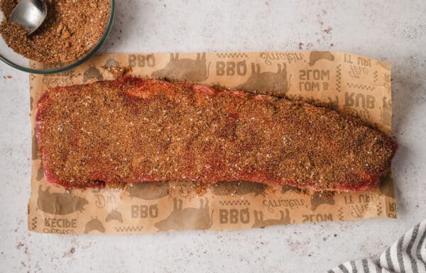 A rack of ribs generously coated with a spice rub