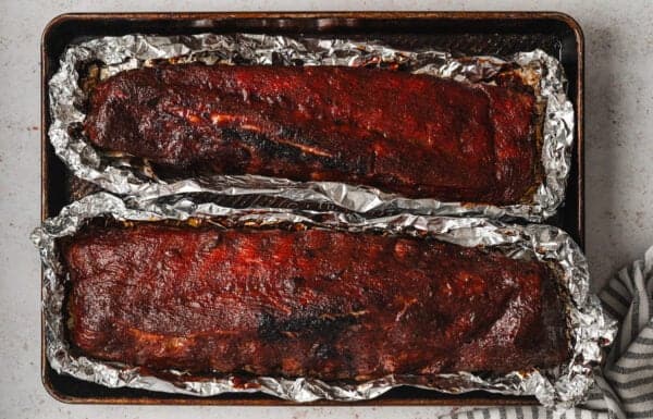 Overhead view of baked baby back ribs on foil