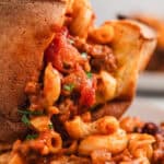 Close up of a chili mac stuffed popover with the chili mac spilling out