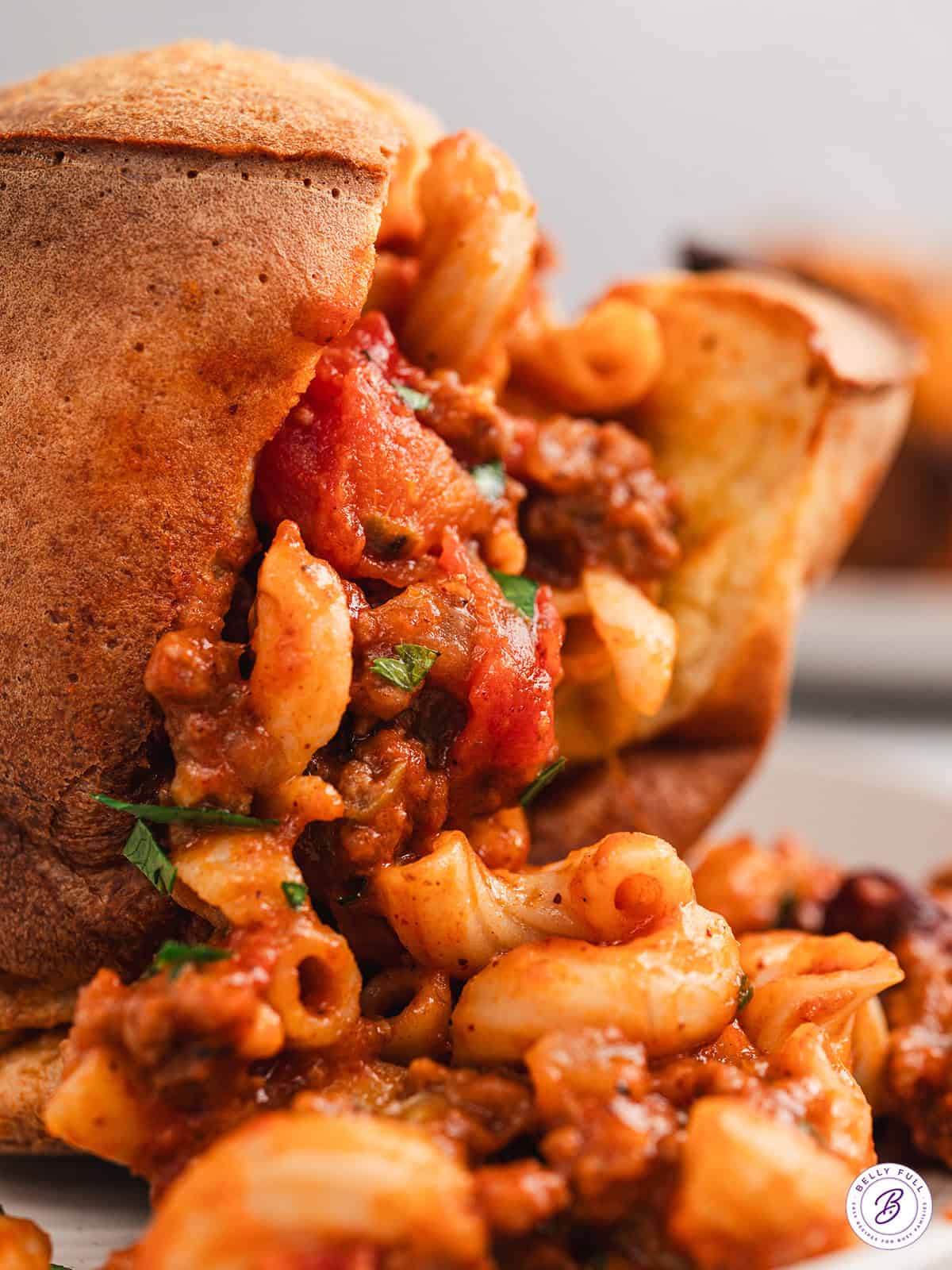 Close up of a chili mac stuffed popover with the chili mac spilling out