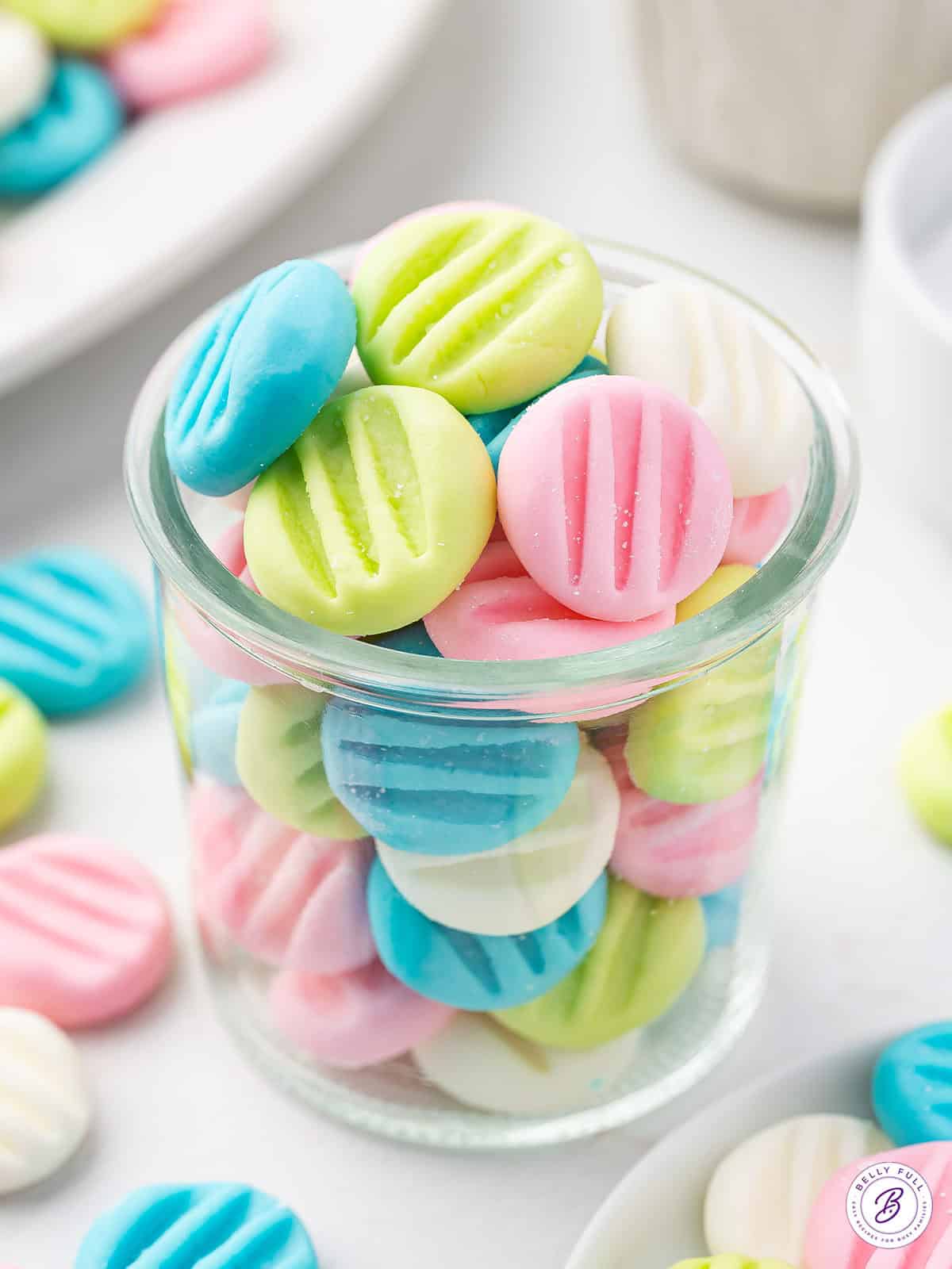 glass jar filled with pastel colored button mints