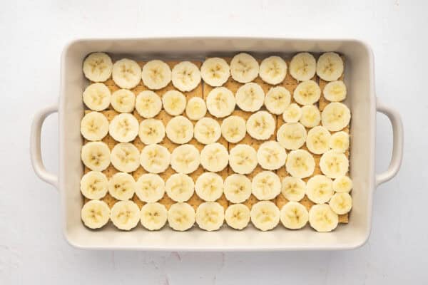 a layer of thin sliced bananas over graham cracker sheets in casserole dish