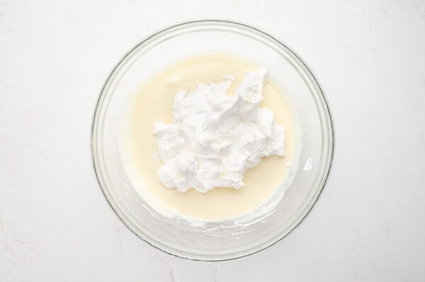 whipped cream on top of pudding mixture in bowl