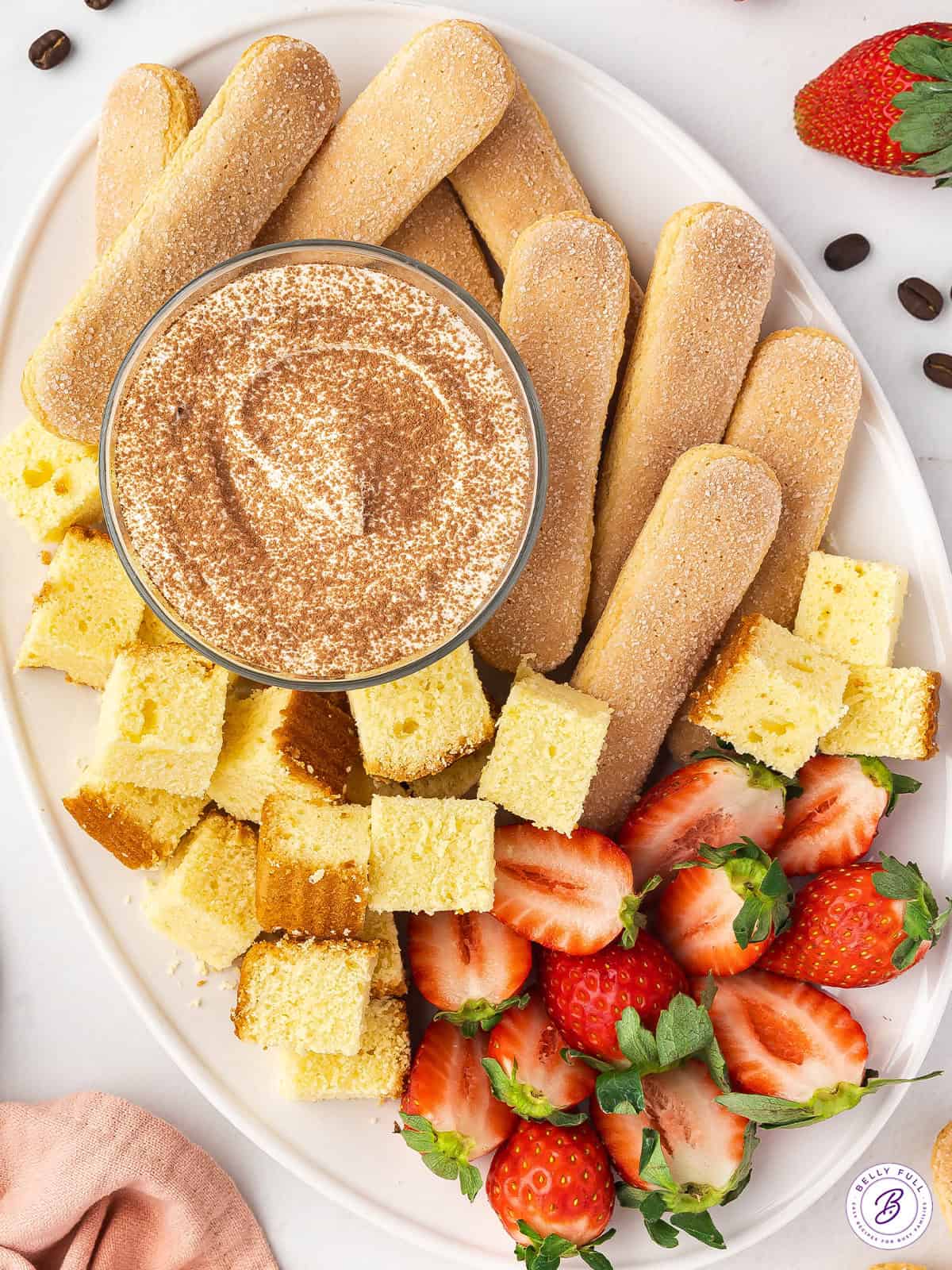 overhead Tiramisu Dip on serving tray with with ladyfingers, pound cake cubes, and strawberries for dippers