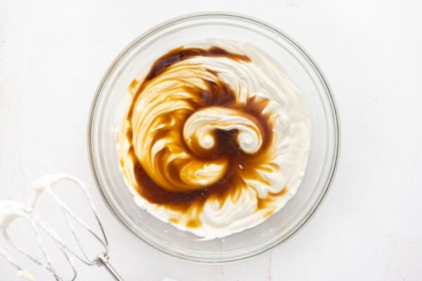 whipped mascarpone cheese and heavy cream cream with coffee in glass mixing bowl