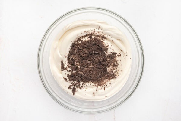 whipped mousse with grated chocolate on top in glass mixing bowl