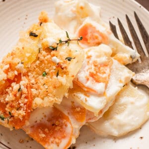 A serving of Yukon and sweet potato gratin on a plate