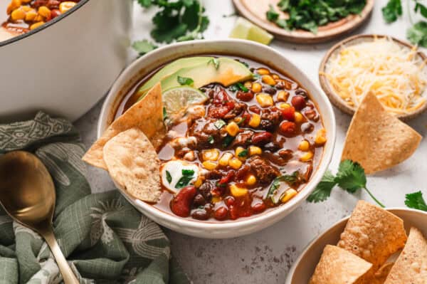 A bowl of 7 can soup with tortlla chips and avocado slices