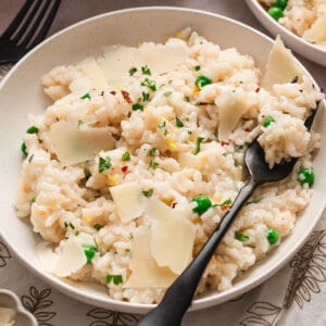 A black spoon in a bowl of baked risotto