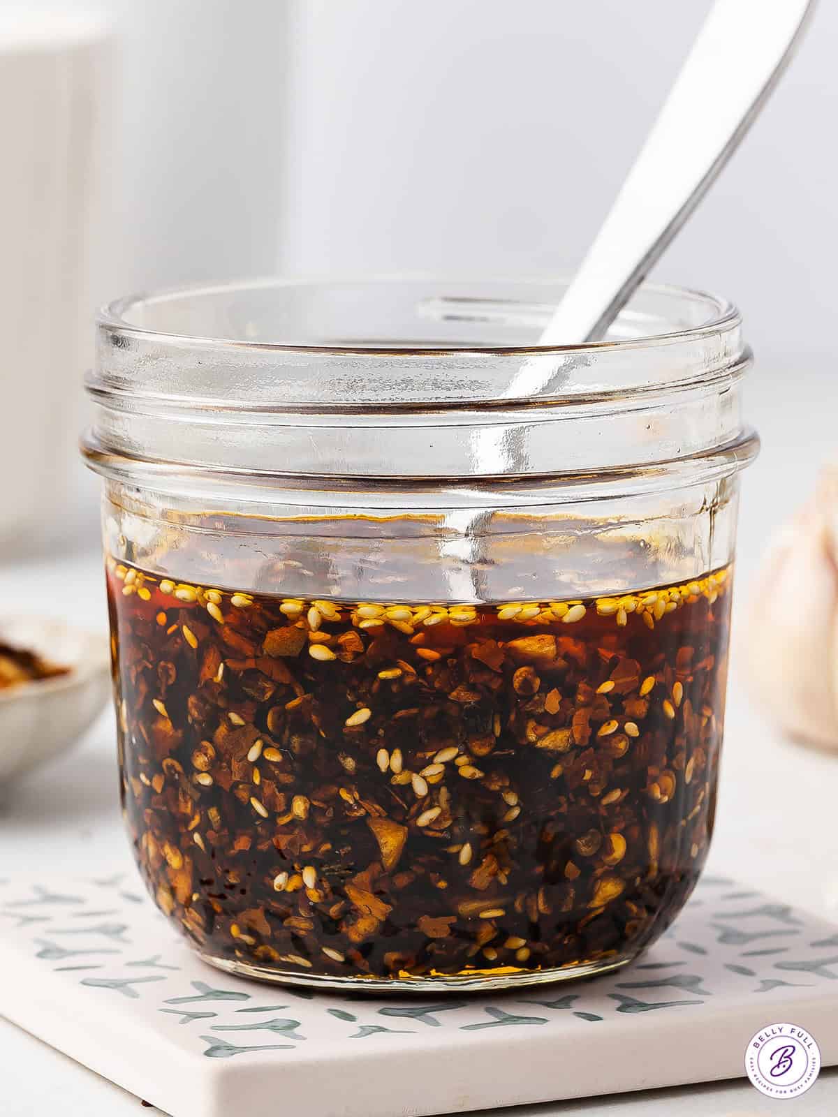 A spoon in a jar of homemade chili crisp