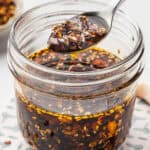 A spoonful of chili crisp over a jar