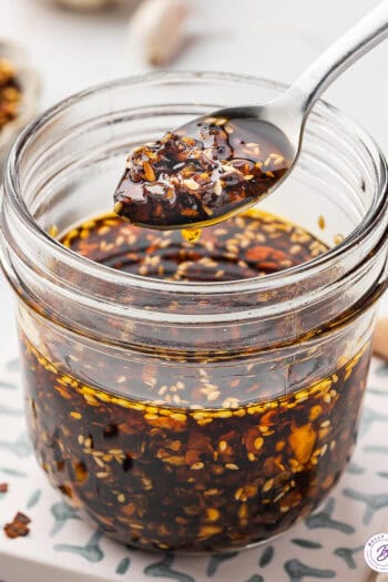 A spoonful of chili crisp over a jar