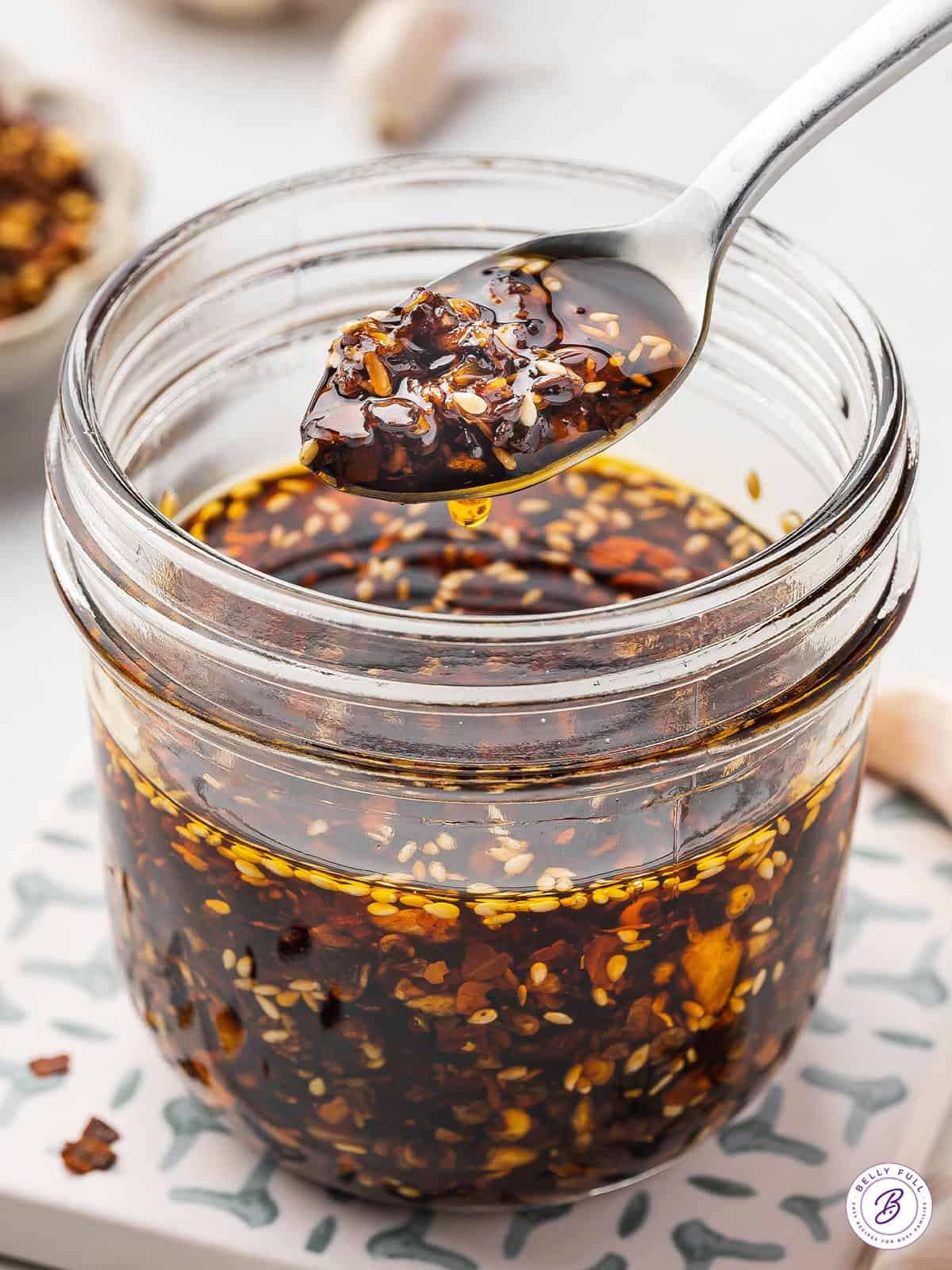 A spoonful of chili crisp over a jar