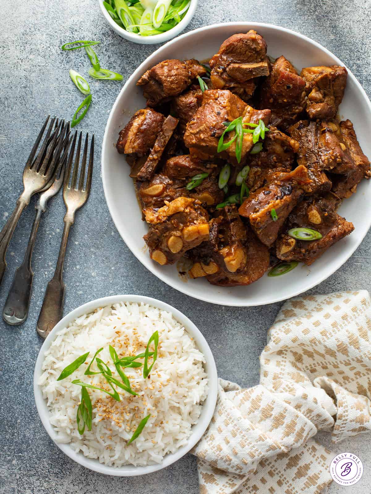 Chinese pork spare ribs in a bowl next to a bowl of white rice