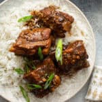 small Chinese pork ribs over rice with sauce and diced scallions