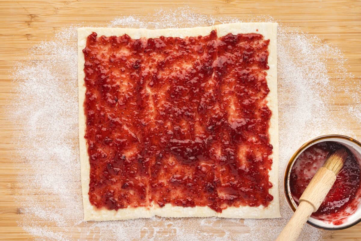 Jam spread on a puff pastry sheet