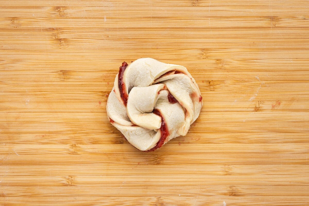 Unbaked jam puff pastry roll on a cutting board