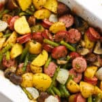 overhead baked sliced kielbasa, mushrooms, onion, and green beans in casserole dish