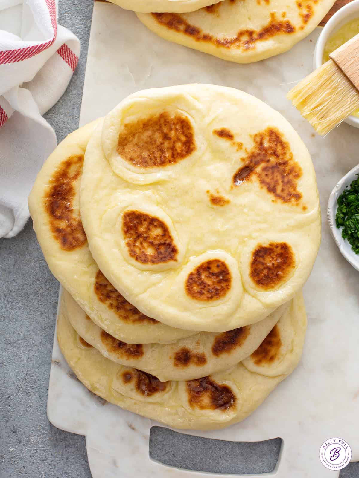 stack of 4 naan on cutting board