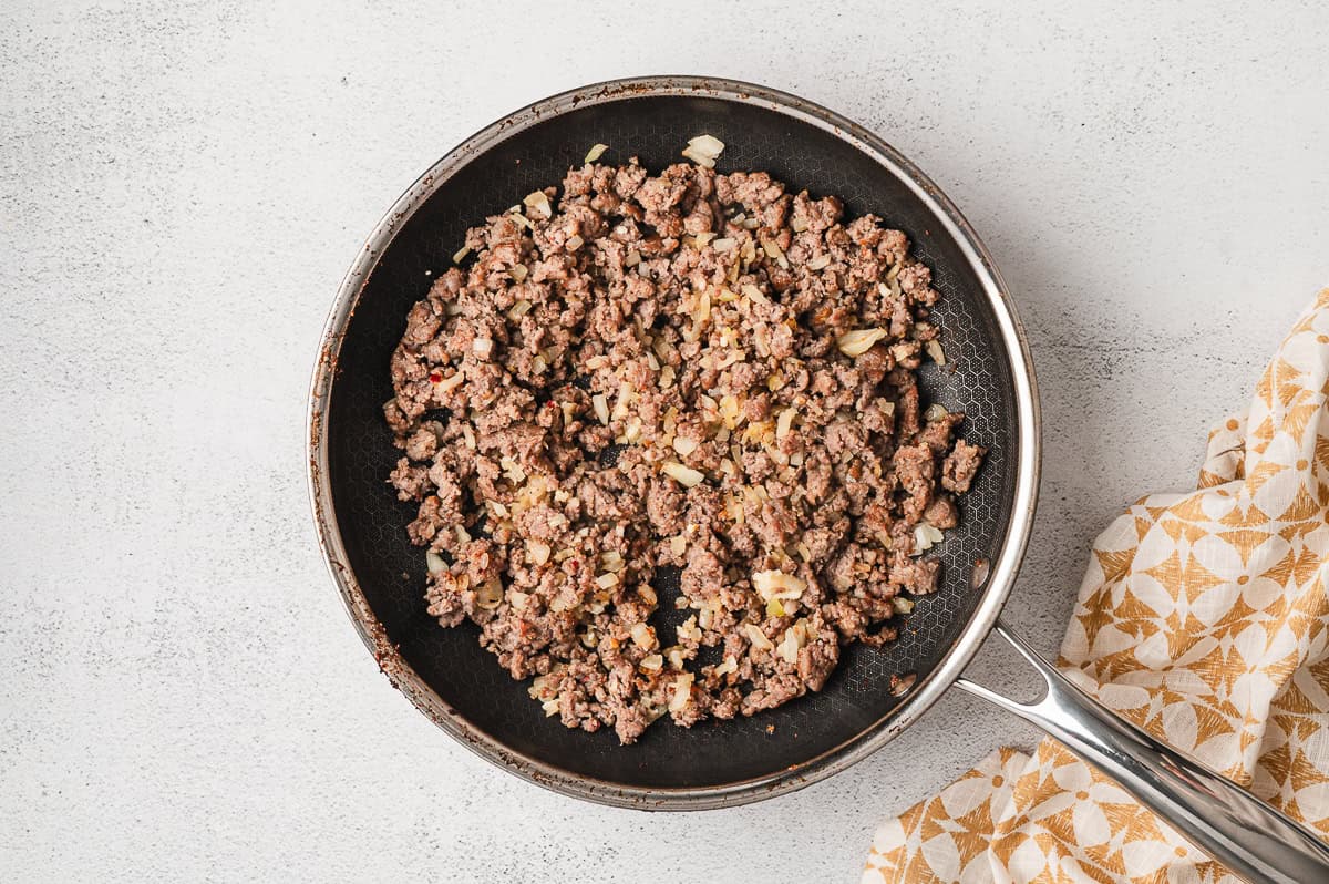 A pan of cooked crumbled sausage
