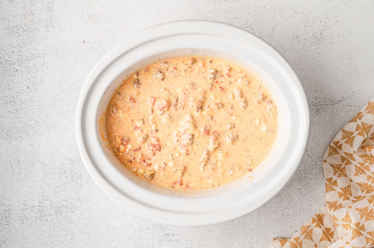 Overhead view of a crockpot with Rotel and sausage cheese dip
