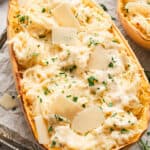 half of a roasted spaghetti squash mixed with alfredo sauce, garnished with parsley