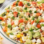 View of a Cobb salad dip showing off the toppings, like bacon, corn, avocado, and feta.