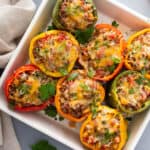 overhead baked stuffed peppers with melted cheese in casserole dish