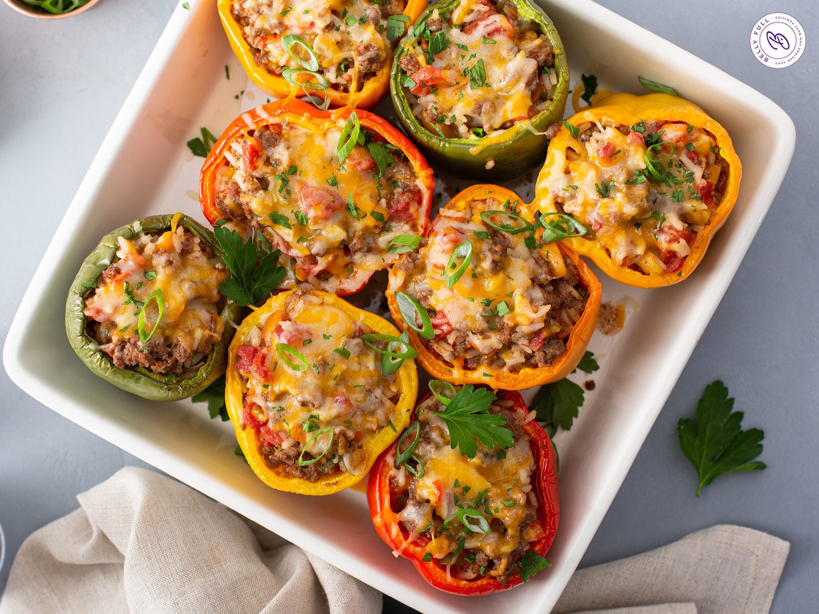 overhead baked stuffed peppers with melted cheese in casserole dish