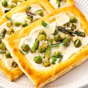 Close up baked golden Asparagus Puff Pastry Tarts on plate