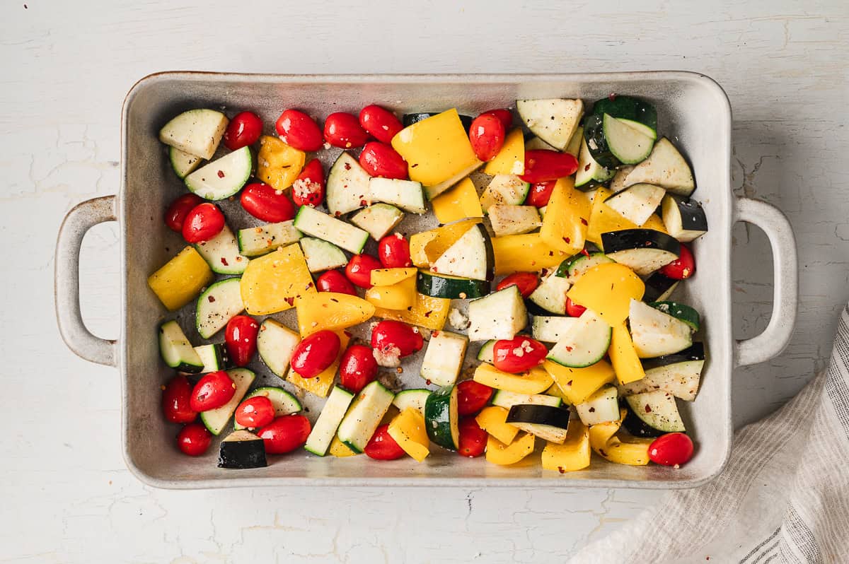 Bell pepper, zucchini, tomatoes, and eggplant on a baking sheet