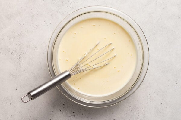 crepe batter in bowl with whisk