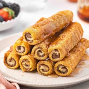 stack of French Toast Rolls on plate with maple syrup