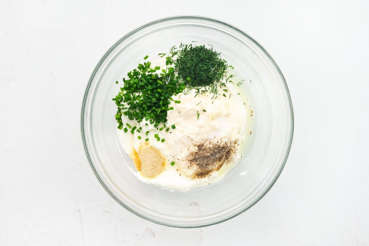Fresh herbs, seasonings, mayo, and cream cheese in a bowl